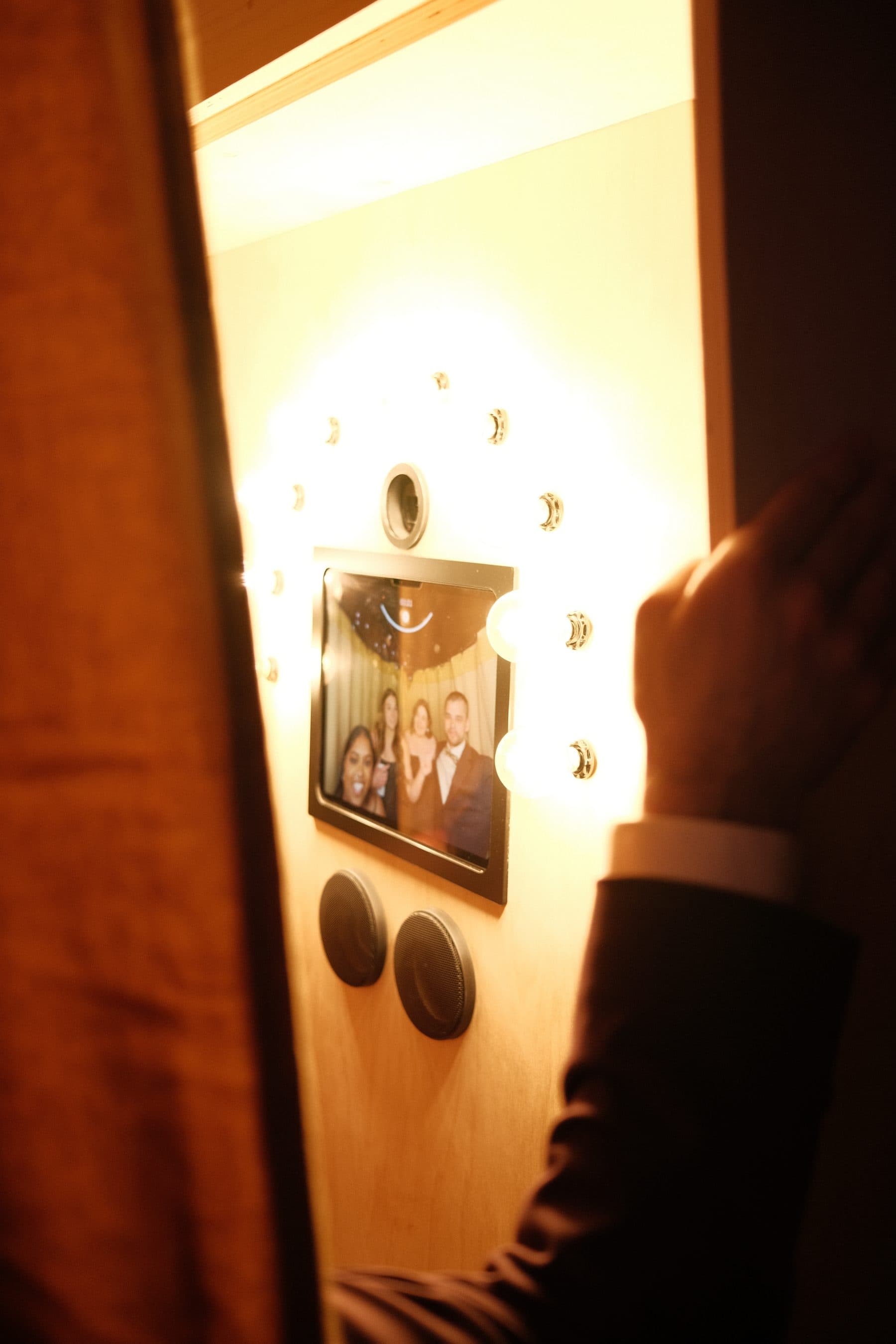 A guest reaching for the booth's touchscreen